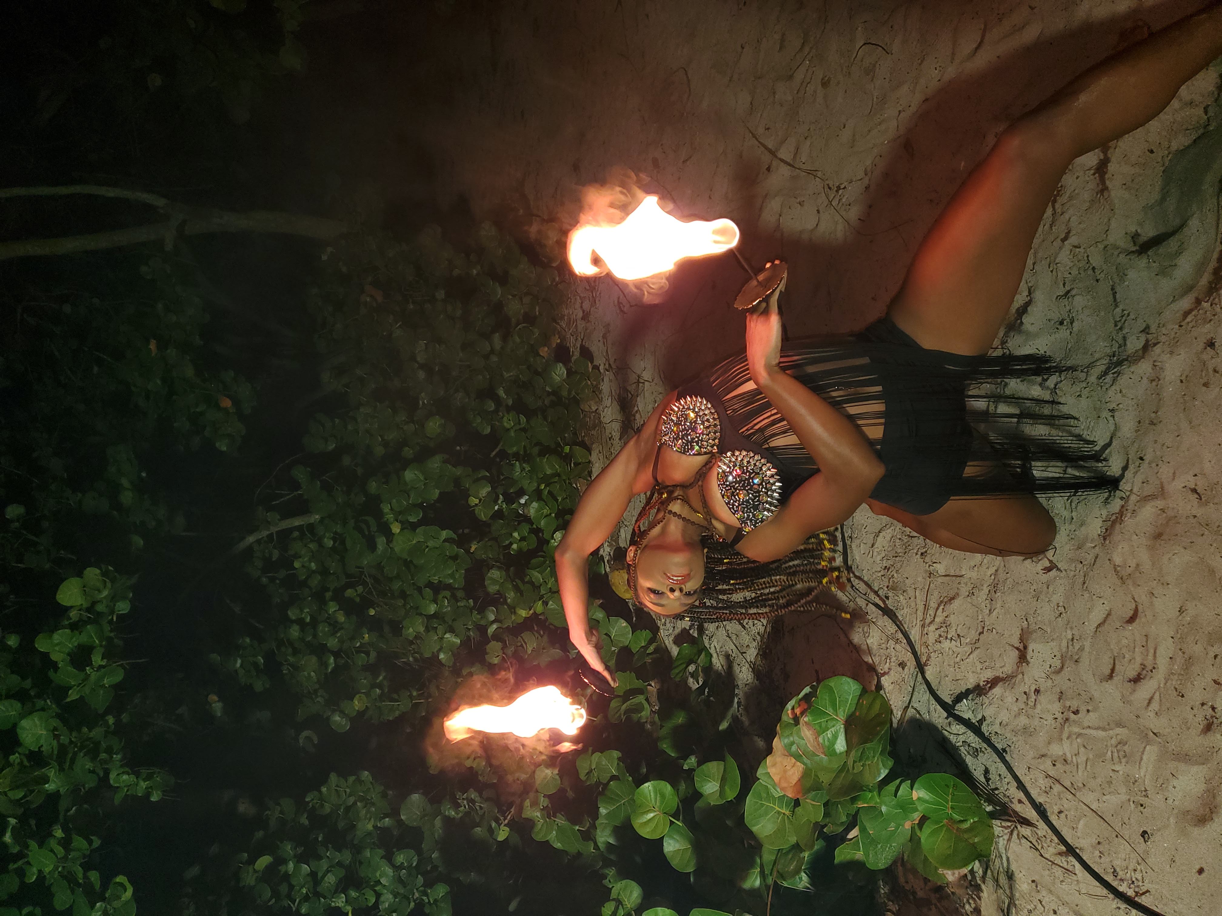 Palm torch performance in black fringe costume